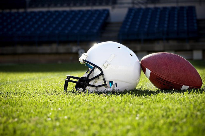 Football Helmet on a stadium field Wall Mural Wallpaper