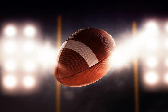 Football ball flying fast through the air Wall Mural Wallpaper