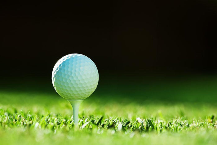Golf ball on green grass Wall Mural Wallpaper