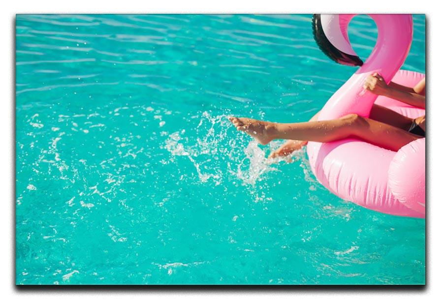 Tan girl sits on inflatable mattress flamingos in the pool Canvas Print or Poster - Canvas Art Rocks - 1