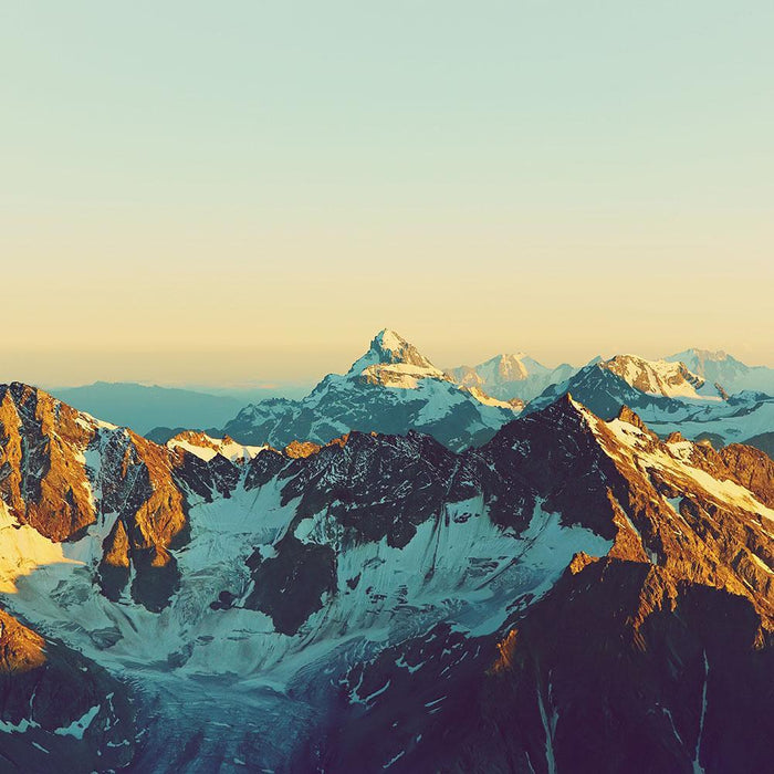 peaks covered by snow and clouds Wall Mural Wallpaper
